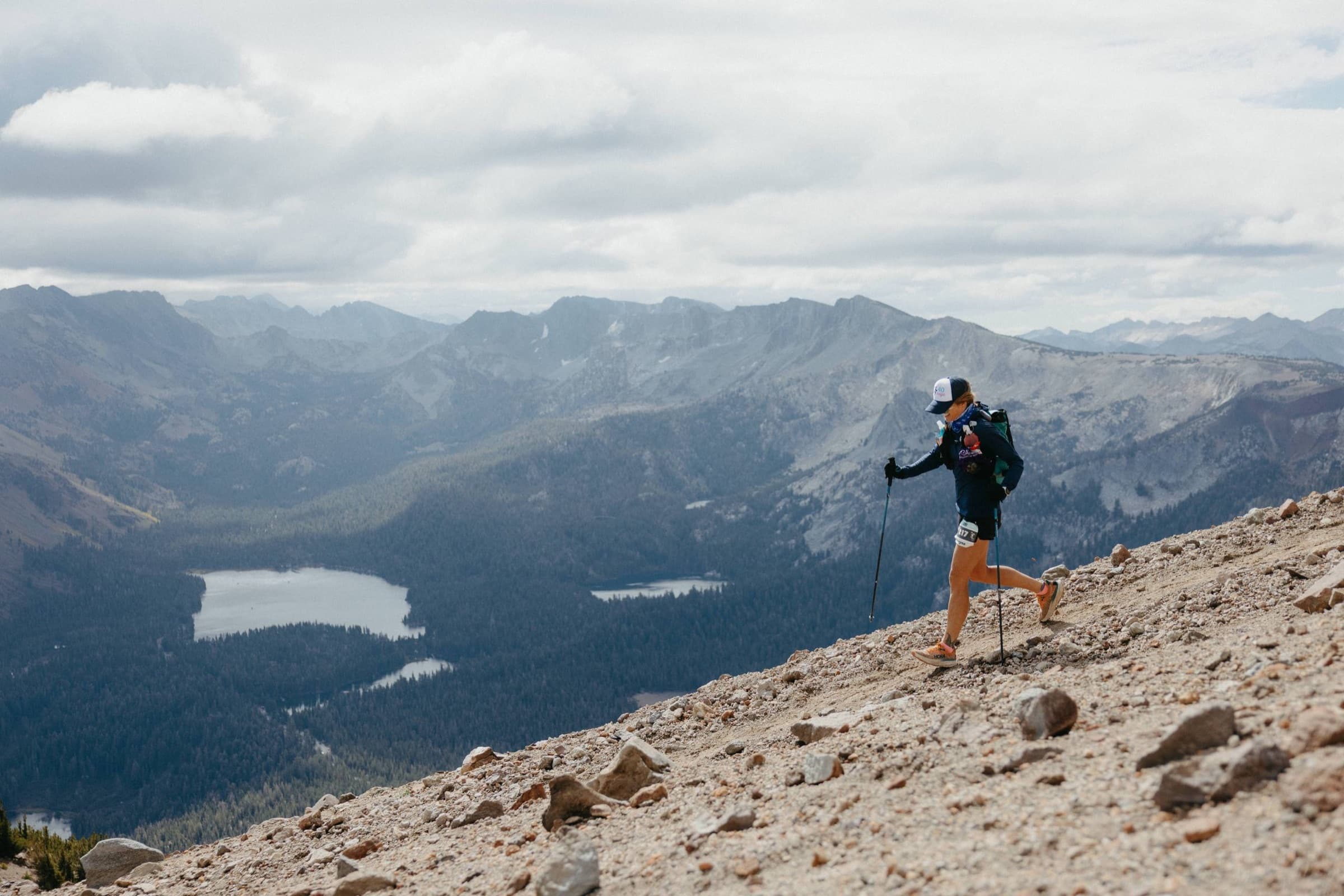A runner descends a rocky ridge above alpine lakes at Mammoth Trailfest